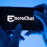 Eine Frau hält ein Smartphone mit dem Logo des Krypto-Messengerdienstes Encrochat (gestellte Szene).