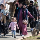 Flüchtlinge aus Afghanistan tragen Kinder und Koffer.