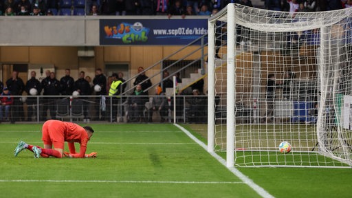 Werder-Torwart Jiri Pavlenka kniet im Strafraum und schaut dem Ball hinterher, der im Tornetz zappelt.