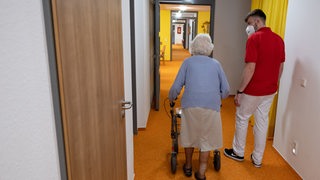 Pfleger und alte Dame im Altenheim