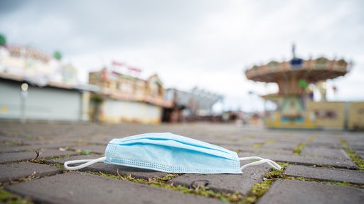 Eine Mund- und Nasenschutzmaske liegt auf dem Gelände des "Bremer Freipaaks" an der Bürgerweide. 