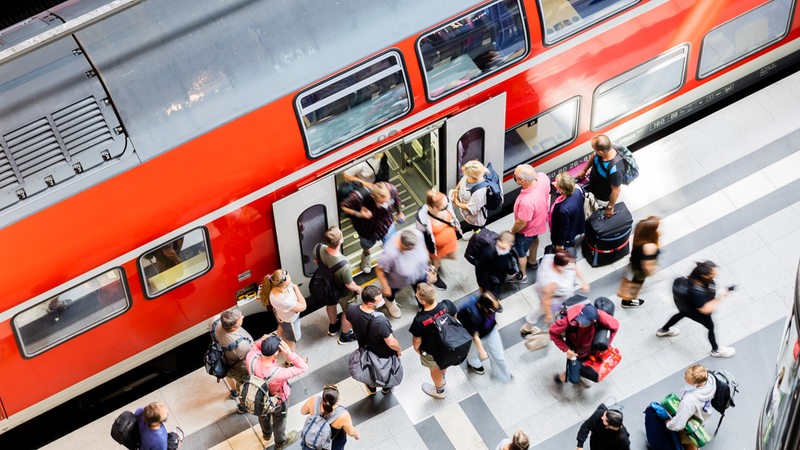 Fahrgäste steigen am Berliner Hauptbahnhof aus einem Regionalexpress aus. 