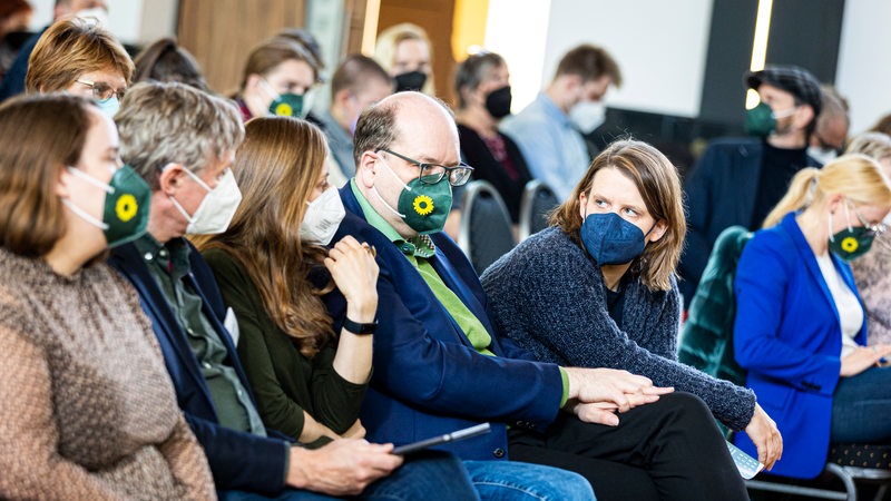 Mehrere Grünen-Politiker reden beim Parteitag miteinander.