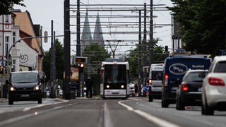Eine Straßenbahn und Autos fahren morgens im Berufsverkehr durch Bremen.
