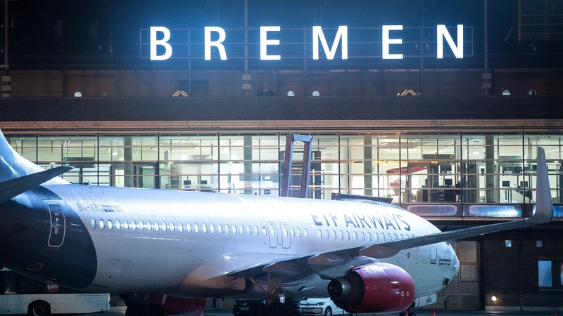 Ein Flugzeug steht nachts auf dem Rollfeld vom Flughafen Bremen.