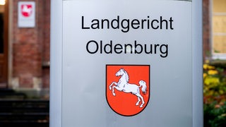 Ein Schild mit dem niedersächsischen Landeswappen steht am Eingang zum Landgericht Oldenburg. 