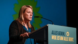 Die Spitzenkandidatin der Bremer Grünen für die Bürgerschaftswahl, Maike Schaefer, steht an einem Mikrofon.