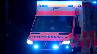 Ein Rettungswagen fährt bei Nacht mit Blaulicht.