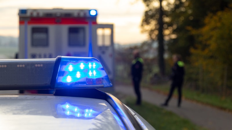 Ein Einsatzfahrzeug der Polizei steht mit Blaulicht an einem Unfallort