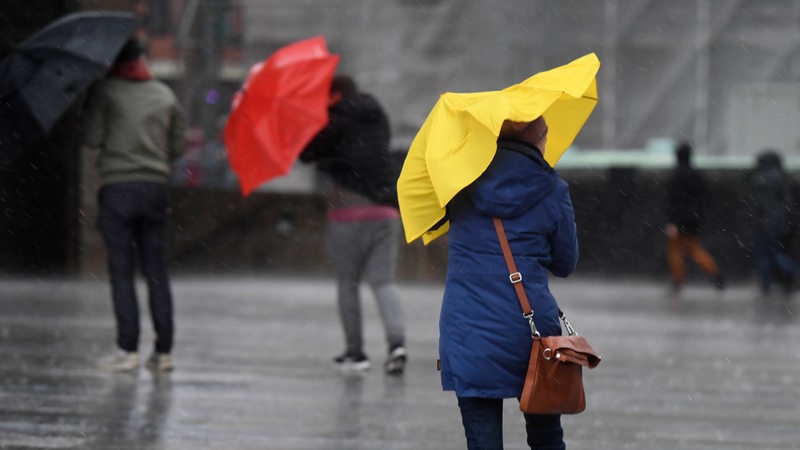 Frau mit Schirm bei Regenwetter