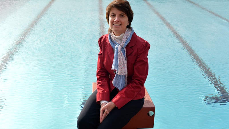Martina Baden, Geschäftsführerin bei den Bremer Bädern, sitzt auf einem Startblock in einem Schwimmbad in Bremen.