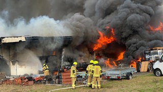 Feuerwehrleute bekämpfen den Brand einer Lagerhalle in Rastede im Kreis Ammerland.