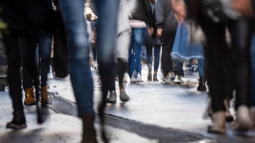 Passanten gehen durch eine Bremer Einkaufsstraße.