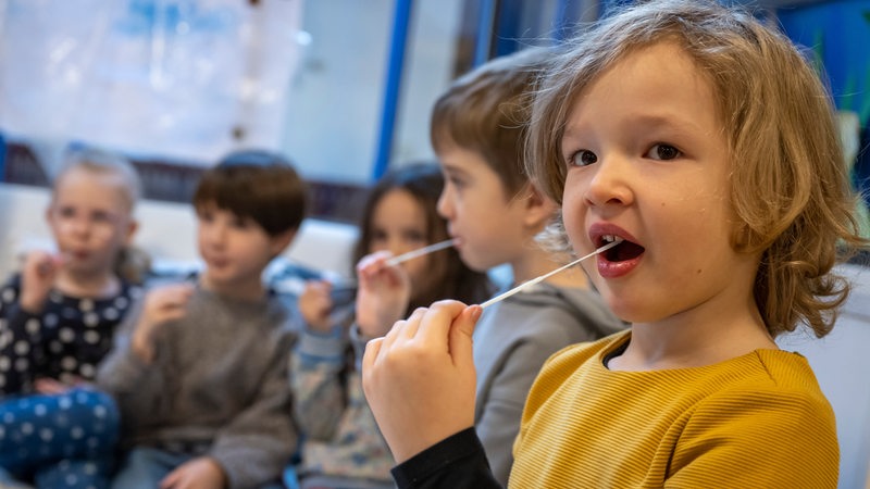 Die Kinder in einer Kindertagesstätte machen einen Corona-Test.