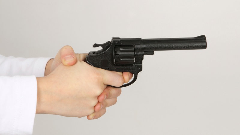 Eine Person hält eine Spielzeugwaffe in den Händen. 