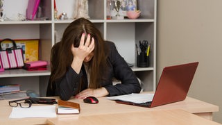 Frau sitzt verzweifelt vor ihrem Laptop