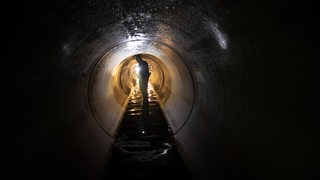 Ein Arbeiter schaut sich in Berlin-Friedenau einen Teil eines neuen, etwa zwei Kilometer langen Wasserkanales unter der Erde an.