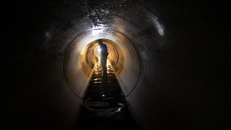 Ein Arbeiter schaut sich in Berlin-Friedenau einen Teil eines neuen, etwa zwei Kilometer langen Wasserkanales unter der Erde an.
