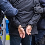 Zwei Polizisten nehmen einen Mann fest