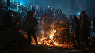 Menschen wärmen sich in der türkischen Erdbebenregion an einem Feuer.