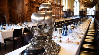Silberschmuck des Hauses Seefahrt steht auf gedeckten Tischen im Festsaal des Bremer Rathauses