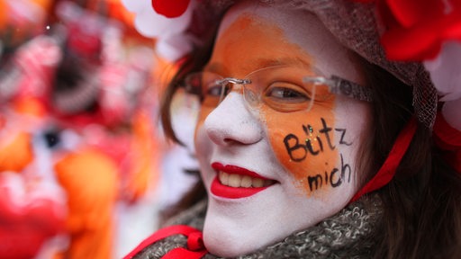 "Bütz mich" (Küß mich) hat sich in Köln eine Karnevalistin ins Gesicht geschrieben.
