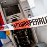 Ein gesprengter Geldautomat ist auf einer Pressekonferenz beim Landeskriminalamt (LKA) zur Vorstellung des Lagebilds der Organisierten Kriminalität hinter einem Flatterband mit der Aufschrift „Polizeiabsperrung“ ausgestellt.