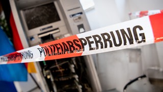 Ein gesprengter Geldautomat ist auf einer Pressekonferenz beim Landeskriminalamt (LKA) zur Vorstellung des Lagebilds der Organisierten Kriminalität hinter einem Flatterband mit der Aufschrift „Polizeiabsperrung“ ausgestellt.