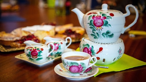 Geschirr mit der traditionellen Ostfriesischen Rose steht auf einem Tisch.
