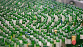 Flaschen mit Beck's Bier laufen in der der Brauerei in Bremen zum Reinigen über das Band.