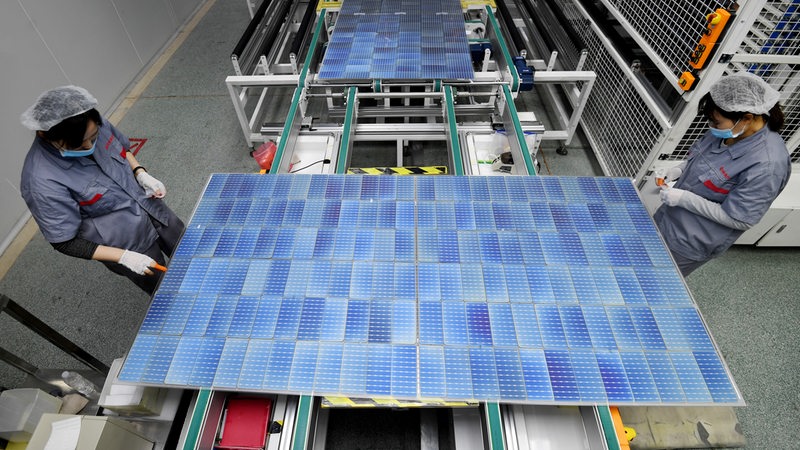 Beschäftigte arbeiten an einer Photovoltaik-Anlage
