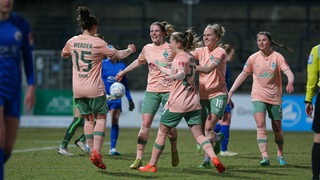 Fußballspielerinnen von Werder Bremen kommen zusammen und bejubeln ihren Treffer gegen Turbine Potsdam.