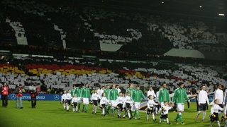 Die deutsche und französische Nationalmannschaft laufen ins Weser-Stadion ein.