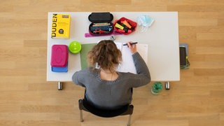 Schülerin an ihrem Tisch während einer Abiprüfung