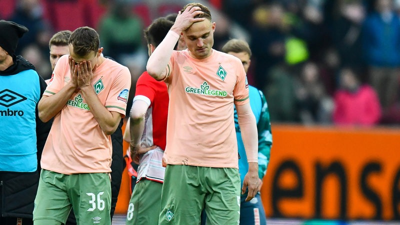 Die Werder-Spieler Christian Groß und Amos Pieper halten sich frustriert nach dem Spiel die Hände vors Gesicht und an den Kopf.