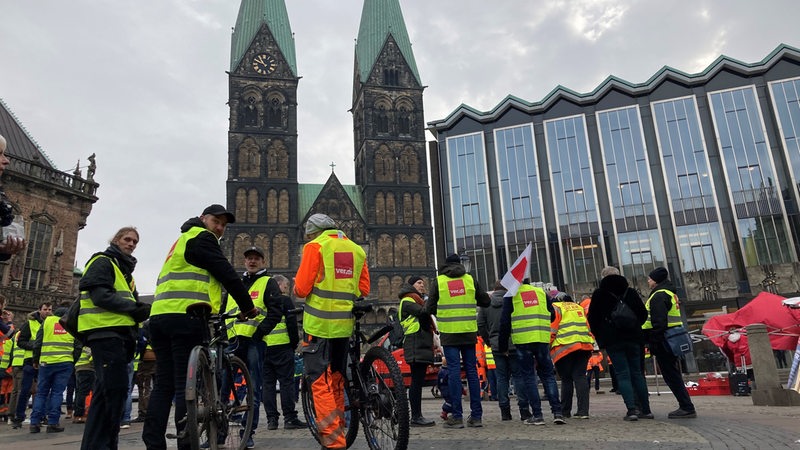 In der Tarifrunde für den öffentlichen Dienst nehmen Mitarbeiter des Umweltbetriebes der Stadt Bremen auf dem Marktplatz an einer Kundgebung der Gewerkschaft Verdi teil.