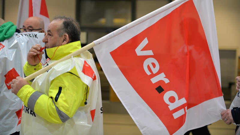 Streikende stehen auf dem Flughafen in Bremen im Terminal. 