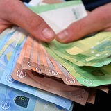 Hände halten viele Euro-Banknoten