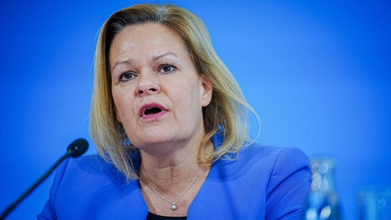 Bundesinnenministerin Nancy Faeser vor blauem Hintergrund.