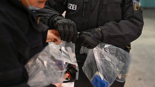 Polizisten kontrollieren sichergestellte Gegenstände 