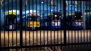 Straßenbahnen stehen in einem Depot hinter verschlossenen Gittern