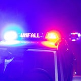 Ein Einsatzfahrzeug der Polizei steht mit Blaulicht und dem Schriftzug Unfall im Display auf einer Straße.