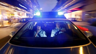 Streifenwagen der Polizei bei einer Alarmfahrt mit Blaulicht und Martinshorn, 