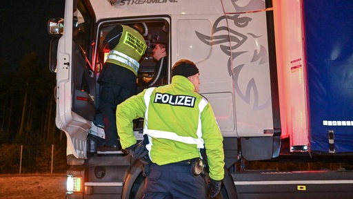 Polizisten kontrollieren einen Transporter.