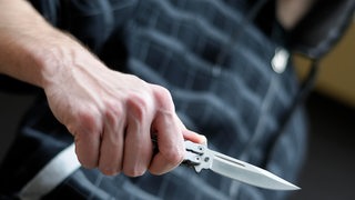 Mann hält ein Messer in der Hand 