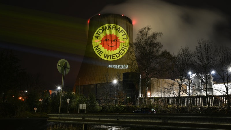 Aktivisten der Anti-Atom-Bewegung projizieren eine große Anti-Atom-Sonne auf den Kühlturm des Atomkraftwerkes Emsland.