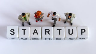 Figuren stehen vor dem Wort "Start-up"