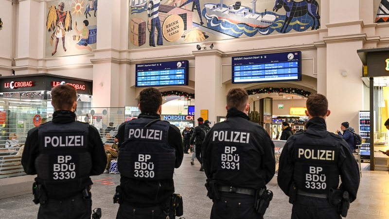 Polizisten stehen in der großen Halle im Bremer Hauptbahnhof.