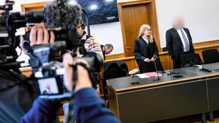 Ein Angeklagter steht mit seiner Anwältin im Saal des Oldenburger Landgerichts.