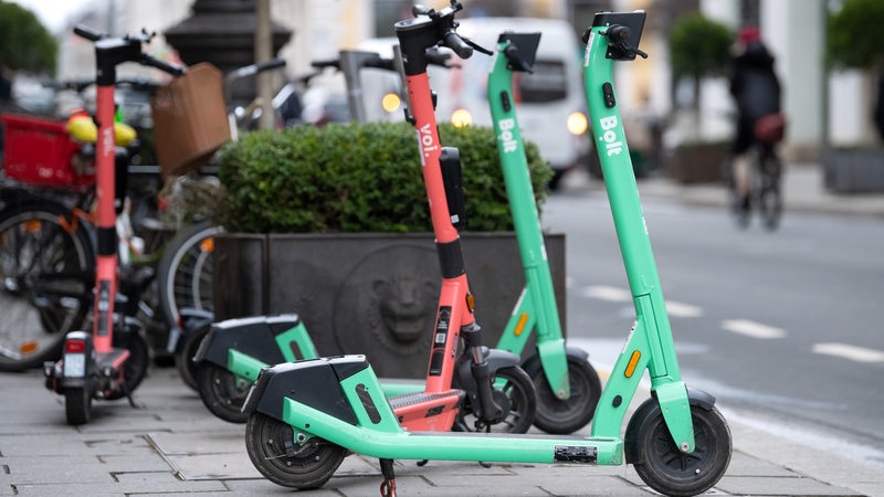 E-Scooter stehen auf einem Gehweg